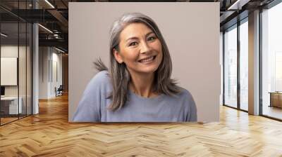 Charming Asian mature woman smiles at camera Wall mural