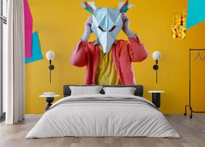 Dressed in eye-catching attire, a man playfully showcases a 3D origami animal mask, embodying creativity and whimsy amid a colorful setting that inspires joy. Wall mural