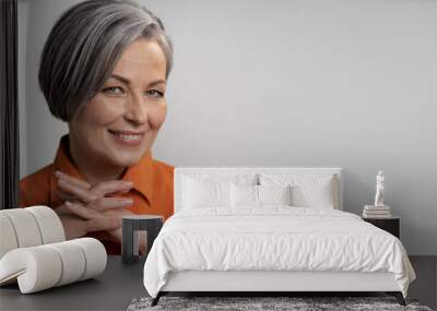 Happy aged woman smiling fingers crossed. Lady with bob hairstyle in orange blouse, head and shoulders portrait. Wisdom concept. Horizontal blank or template with copy spase at right side. Wall mural