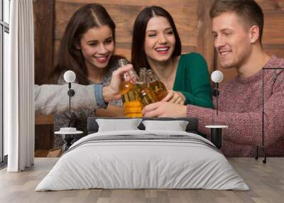 Happy friends resting with alcohol drinks in pizzeria Wall mural