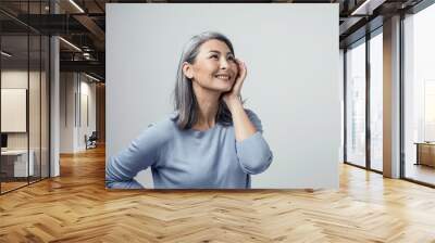 Side profile of charming asian woman smiling on white background Wall mural