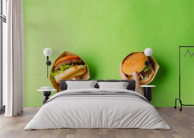 Two people holding up two different types of hamburgers. One is a classic hamburger with lettuce and tomato, while the other is a veggie burger Wall mural