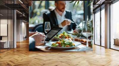 Business lunch meeting - Two professionals discussing business matters over lunch in an upscale restaurant, with documents and a tablet on the table. Wall mural