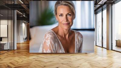 An attractive blonde middle-age woman, poise and elegant, sitting in her bedroom. Closeup portrait of a mature white woman in her 50s, ageing gracefully, looking beautiful and sensual. Wall mural