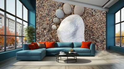 Foot made of pebbles on the sea sand. Wall mural