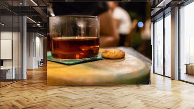 a closeup side view of a glass of tea and cookie Wall mural