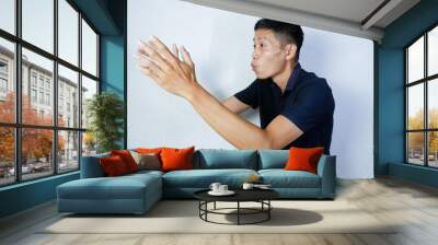 attractive asian man with hand raised up Wall mural