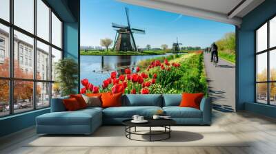 A picturesque Dutch windmill by a tulip field in full bloom, with a clear blue sky Wall mural