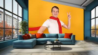 Handsome caucasian young man in red scarf looking to the camera showing fingers doing victory sign or number two. Advertising mockup Wall mural