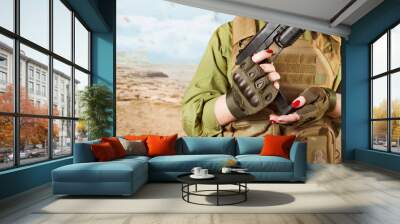 Military soldier woman's hands holding a gun. Wall mural