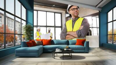 architecture, construction business and building concept - happy smiling male architect in helmet and safety west at office Wall mural