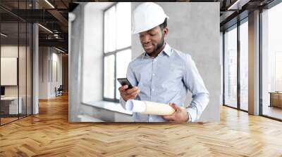 architecture, construction business and people concept - african american architect in helmet with blueprint and smartphone Wall mural