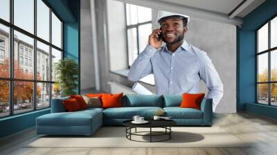 architecture, construction business and people concept - african american architect in helmet with blueprint calling on smartphone Wall mural