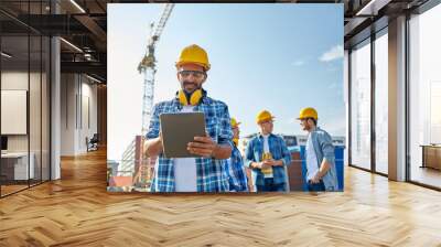 builder in hardhat with tablet pc at construction Wall mural