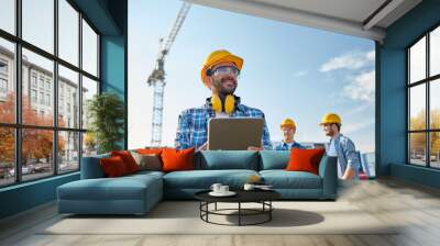 builder in hardhat with tablet pc at construction Wall mural