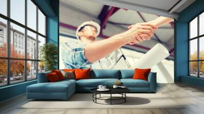 builder with blueprint shaking partner hand Wall mural