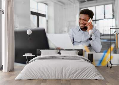 business, people, communication and technology concept - smiling african american businessman with papers and laptop computer calling on smartphone at office Wall mural