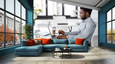 business, people and technology concept - african american businessman with laptop computer working at office Wall mural