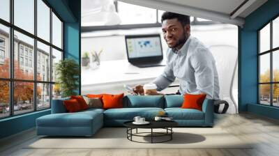 business, people and technology concept - african american businessman with smartphone having break and drinking coffee at office Wall mural