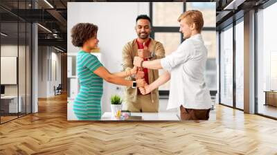 business, teamwork and corporate concept - happy creative team making thumbs up gesture at office Wall mural