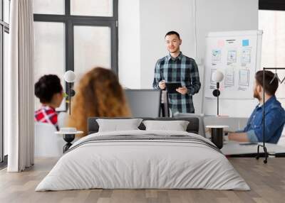 business, technology and people concept - man showing tablet pc computer to creative team at office presentation Wall mural