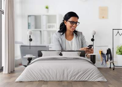 businesswoman with smartphone and laptop at office Wall mural