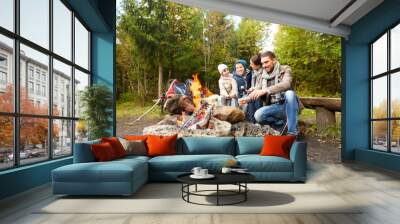 camping, travel, tourism, hike and people concept - happy family roasting marshmallow over campfire Wall mural