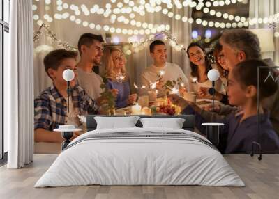 celebration, holidays and christmas concept - happy family with sparklers having fun at dinner party at home Wall mural