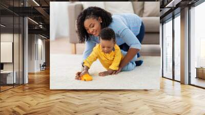 childhood, kids and people concept - happy african american mother and her baby son playing with toy car together on sofa at home Wall mural