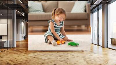 childhood and people concept - happy three years old baby girl playing with toy car at home Wall mural