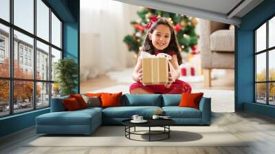 christmas, holidays and childhood concept - happy girl with gift box at home Wall mural