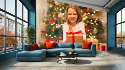 christmas, holidays and childhood concept - smiling girl with gift box at home Wall mural