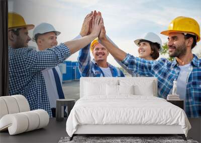 close up of builders in hardhats making high five Wall mural