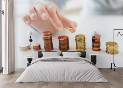 close up of female hand putting coins into columns Wall mural