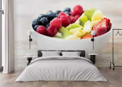 close up of fruits and berries in bowl on table Wall mural