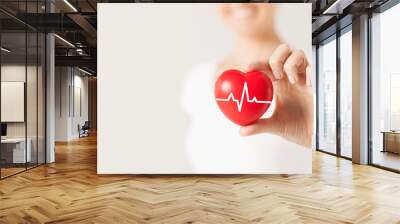 close up of hand with cardiogram on red heart Wall mural