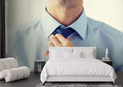 close up of man in shirt adjusting tie on neck Wall mural