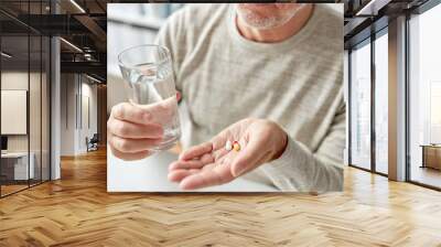 close up of old man hands with pills and water Wall mural