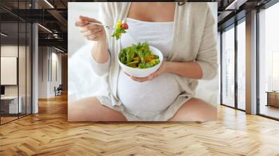 close up of pregnant woman eating salad at home Wall mural