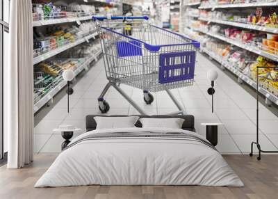 consumerism concept - empty shopping cart or trolley at supermarket Wall mural