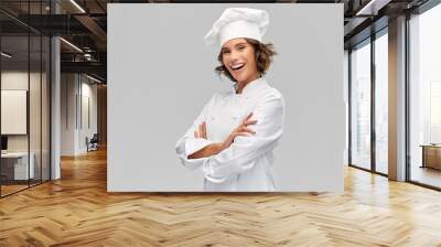 cooking, culinary and people concept - happy smiling female chef in toque with crossed arms over grey background Wall mural