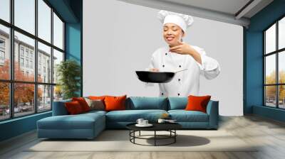 cooking, culinary and people concept - happy smiling female chef with frying pan smelling food over grey background Wall mural