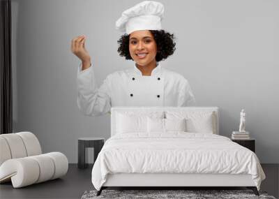 culinary and people concept - happy smiling female chef in toque with saucepan cooking food showing gourmet sign over grey background Wall mural