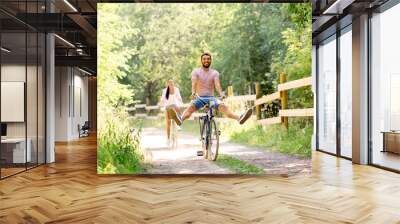 cycling, leisure and lifestyle concept - happy young couple with bicycles at summer park Wall mural