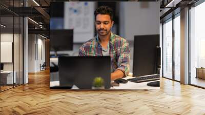 deadline, technology and people concept - creative man with laptop computer working at night office Wall mural