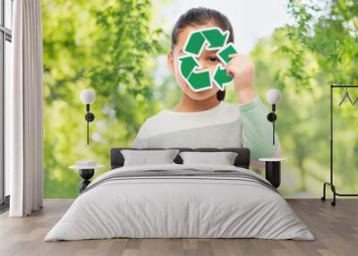 eco living, environment and sustainability concept - smiling girl holding green recycling sign over natural background Wall mural