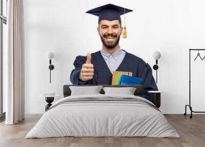 education, graduation and people concept - happy smiling male graduate student in mortar board and bachelor with books gown showing thumbs up over grey background Wall mural