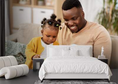 family, fatherhood and people concept - happy african american father reading book for baby daughter at home Wall mural