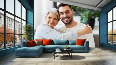 family, generation and people concept - happy smiling senior mother with adult son hugging at home Wall mural