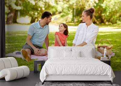 family, leisure and people concept - happy mother, father and daughter having picnic at summer park Wall mural